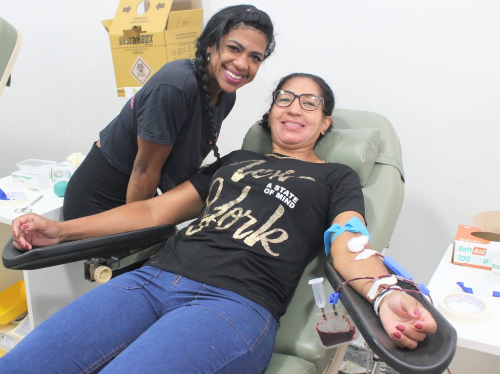 Imagem mostra mulher feliz doando sangue